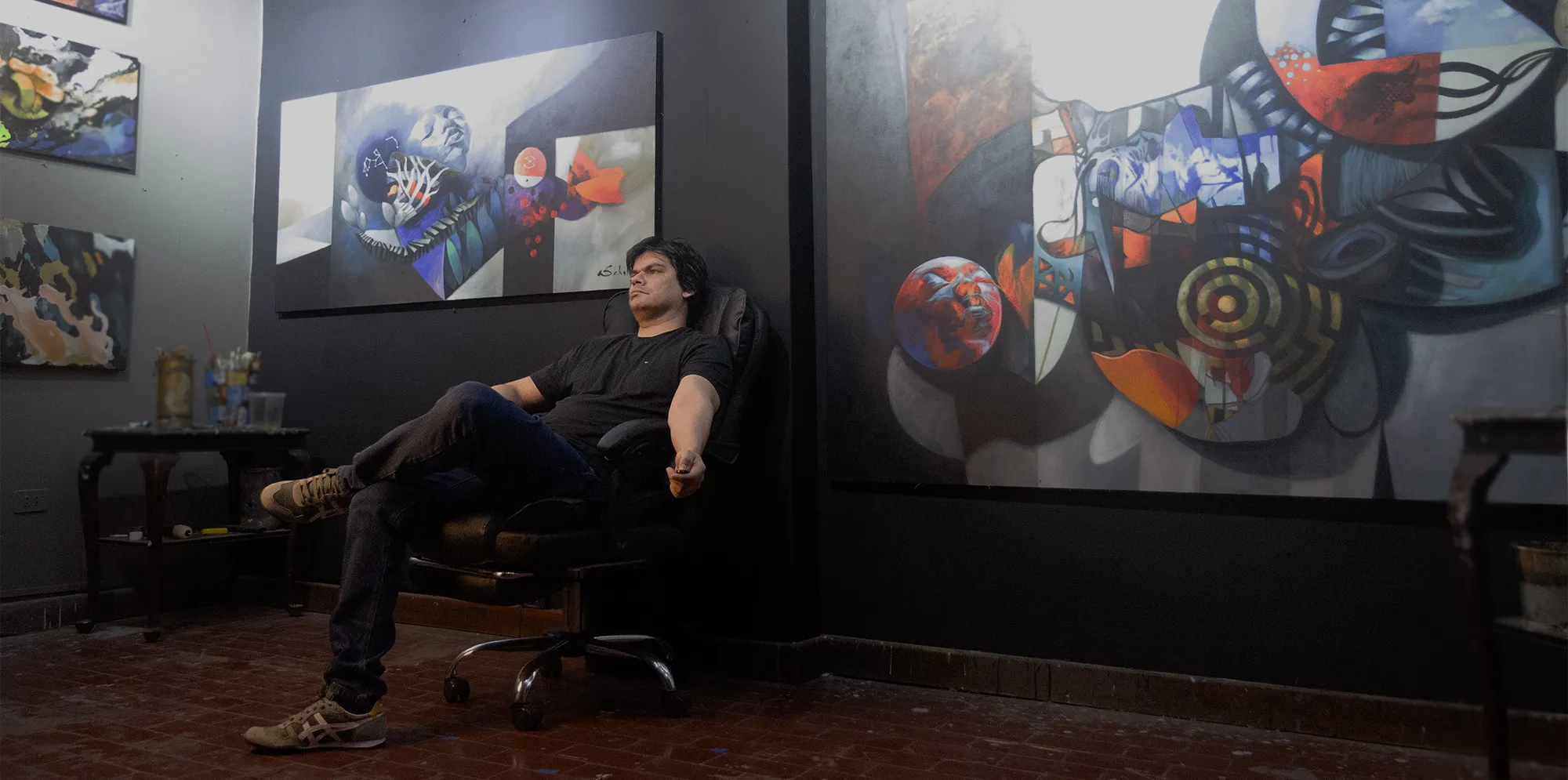 Aldo Acosta Scholz, artista contemporáneo, junto a una de sus obras originales